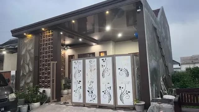 Fasad rumah dengan pagar panel laser-cut motif daun